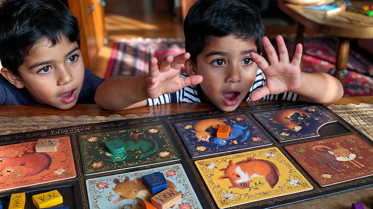 par de niños jugando a las cartas